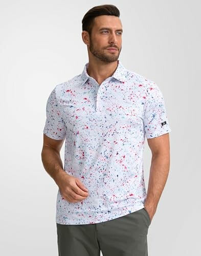 Man wearing a white shirt with splatter paint design and gray pants.